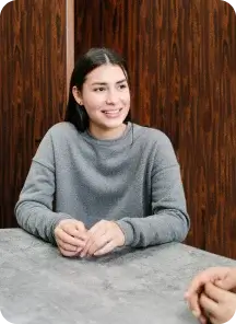 Smiling woman in a grey sweater.